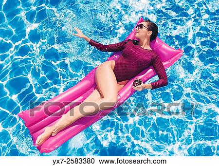 Woman on a air mattress in a swimming pool. View Large Photo Image Stock Image - Woman on a air mattress in a swimming pool.. Fotosearch