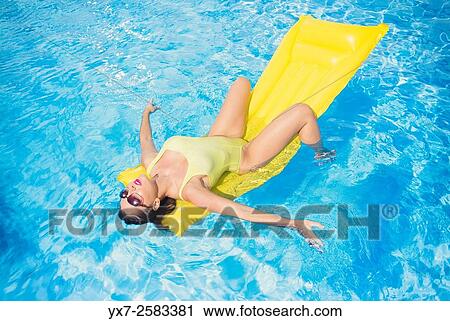 Woman on a air mattress in a swimming pool. View Large Photo Image Stock Image - Woman on a air mattress in a swimming pool.. Fotosearch