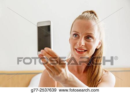 Woman taking a selfie View Large Photo Image Stock Photo - Woman taking a selfie. Fotosearch