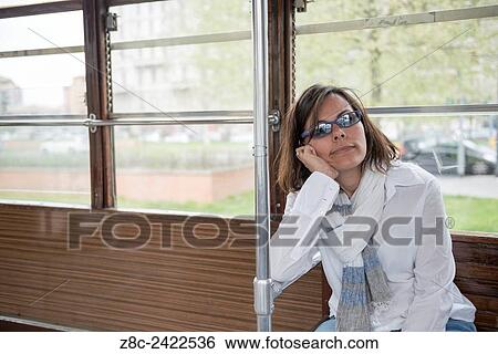 Woman traveling relaxed in a Tram in Milan, Italy. View Large Photo Image Stock Photograph - Woman traveling relaxed in a Tram in Milan, Italy.. Fotosearch