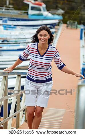 Woman walking in the marina. Port. Getaria. Gipuzkoa. Basque Country. Spain View Large Photo Image Stock Photograph - Woman walking in the marina. Port. Getaria. Gipuzkoa. Basque Country. Spain. Fotosearch
