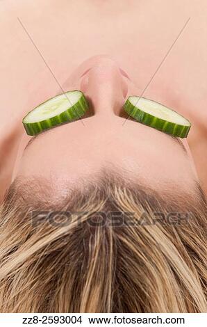 Woman with slices of cumbers covering her eyes. View Large Photo Image Picture - Woman with slices of cumbers covering her eyes.. Fotosearch