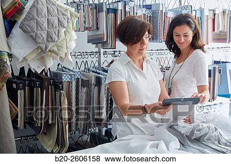 Stock Photo - Women entrepreneurs. Fabric colors and upholstery. Decoration store. Donostia. San Sebastian. Gipuzkoa. Basque Country. Spain. Fotosearch