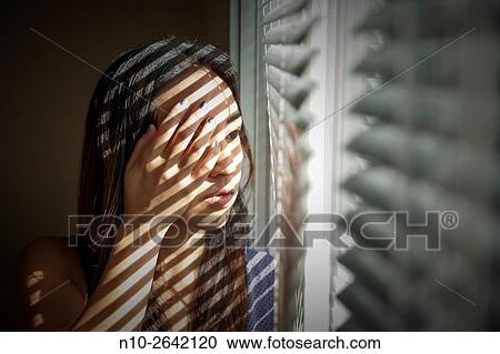 Young Asian woman by a window. View Large Photo Image Stock Image - Young Asian woman by a window.. Fotosearch
