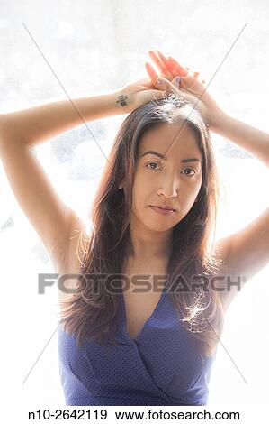 Young Asian woman by a window. View Large Photo Image Stock Photo - Young Asian woman by a window.. Fotosearch