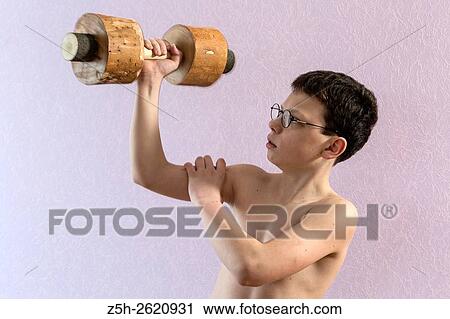 Stock Image - Young athlete exercise with wooden dumbbells.. Fotosearch