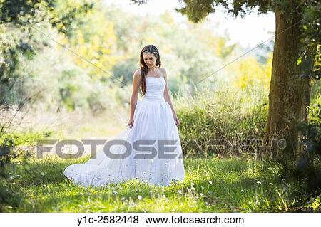 Young bride in nature trailing long dress View Large Photo Image Stock Photo - Young bride in nature trailing long dress. Fotosearch