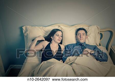 Young couple on their bed. View Large Photo Image Stock Photo - Young couple on their bed.. Fotosearch