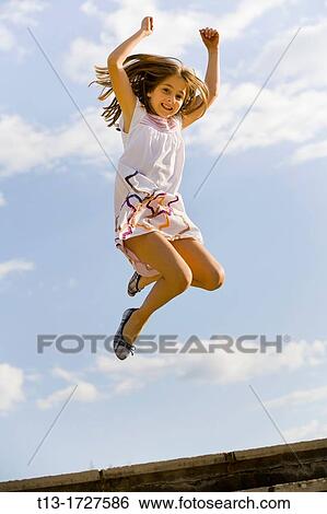 Young girl caught in mid-air View Large Photo Image Stock Photograph - Young girl caught in mid-air. Fotosearch