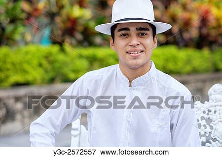 Young hispanic man in formal clothes, wearing white shirt, pants and hat, smiling at camera. View Large Photo Image Stock Photo - Young hispanic man in formal clothes, wearing white shirt, pants and hat, smiling at camera.. Fotosearch