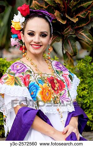 Young hispanic woman smiling while wearing Mexican folklore outfit. View Large Photo Image Stock Image - Young hispanic woman smiling while wearing Mexican folklore outfit.. Fotosearch