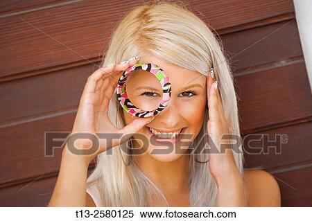 Young lady peeking through bracelet ring View Large Photo Image Stock Photography - Young lady peeking through bracelet ring. Fotosearch