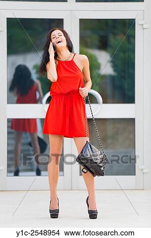 Young lady with cellphone in hand laughing. View Large Photo Image Picture - Young lady with cellphone in hand laughing.. Fotosearch