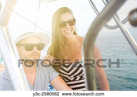 Young man and young woman enjoying a boat ride on vacation. View Large Photo Image Stock Image - Young man and young woman enjoying a boat ride on vacation.. Fotosearch
