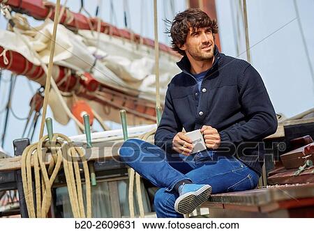 Stock Image - Young man on the outside of a sailboat, galleon. Masts. Basque Country. Spain. Fotosearch