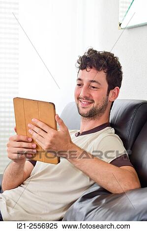 Young man with digital tablet View Large Photo Image Stock Photography - Young man with digital tablet. Fotosearch