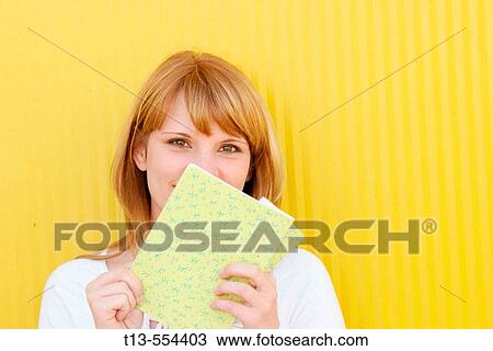 Young schoolgirl portrait smiles behind a notebook View Large Photo Image Stock Image - Young schoolgirl portrait smiles behind a notebook. Fotosearch