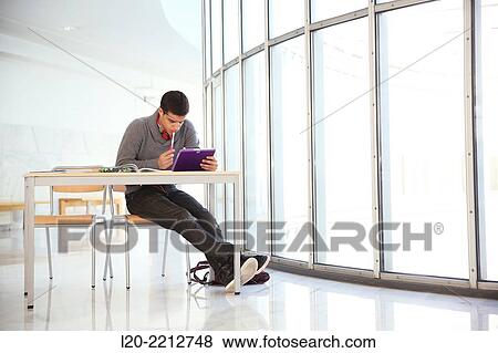 Stock Photo - Young student with digital tablet at campus. Fotosearch