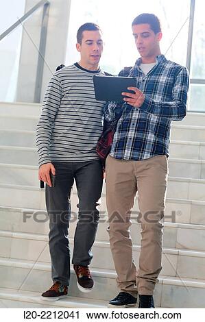 Young students at campus using digital tablet View Large Photo Image Stock Image - Young students at campus using digital tablet. Fotosearch