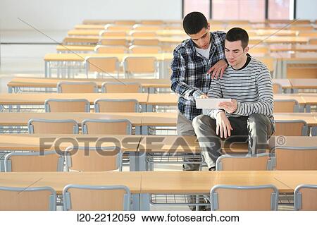 Young students at campus using digital tablet View Large Photo Image Stock Photo - Young students at campus using digital tablet. Fotosearch