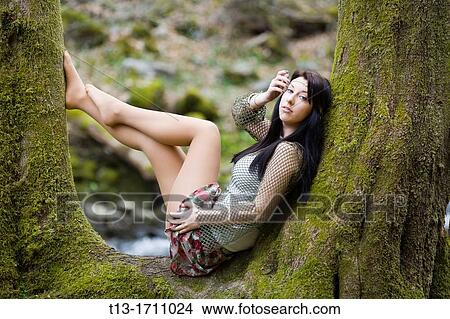 Young teen posing on a tree View Large Photo Image Picture - Young teen posing on a tree. Fotosearch