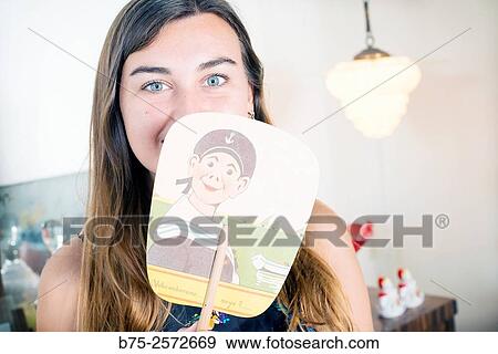 Young teen with long brown hair and blue eyes, looking at the camera, with a fan in a hand covering her mouth View Large Photo Image Stock Photo - Young teen with long brown hair and blue eyes, looking at the camera, with a fan in a hand covering her mouth. Fotosearch