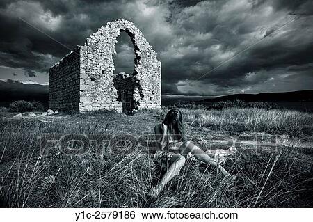 Stock Photograph - Young woman before derelict stone building Black & White retro. Fotosearch