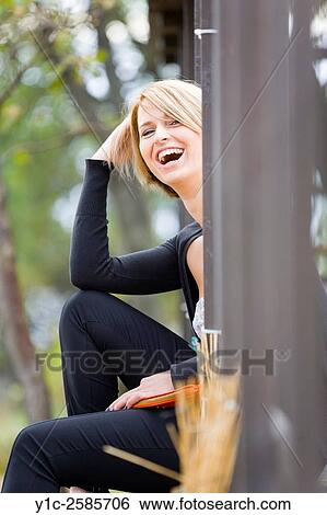 Young woman behind corner laughing loudly View Large Photo Image Stock Photograph - Young woman behind corner laughing loudly. Fotosearch