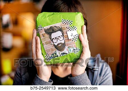 Young woman covering her face with a parcel present with an Hipster drawing on. View Large Photo Image Stock Image - Young woman covering her face with a parcel present with an Hipster drawing on.. Fotosearch