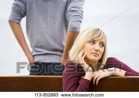 Stock Image - Young woman daydreaming in park. Fotosearch
