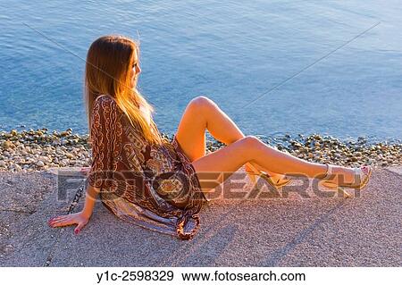Young woman enjoy sunset warm light with legs exposed View Large Photo Image Stock Photo - Young woman enjoy sunset warm light with legs exposed. Fotosearch