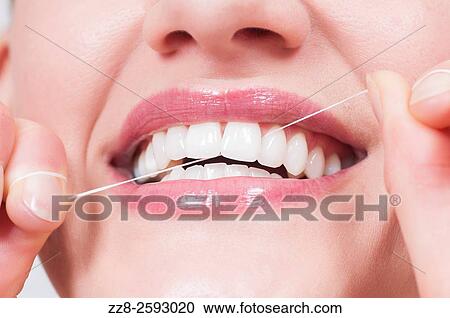 Young woman flossing her clean white teeth. View Large Photo Image Stock Image - Young woman flossing her clean white teeth.. Fotosearch
