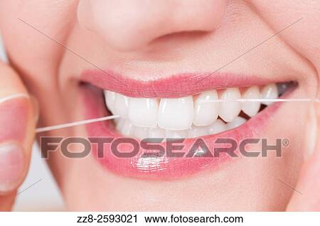 Young woman flossing her clean white teeth. View Large Photo Image Stock Image - Young woman flossing her clean white teeth.. Fotosearch