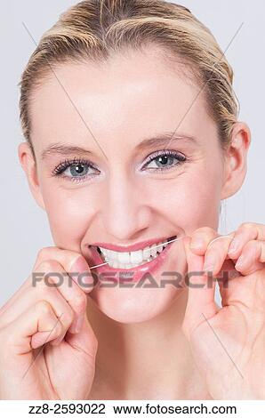 Young woman flossing her clean white teeth. View Large Photo Image Stock Image - Young woman flossing her clean white teeth.. Fotosearch