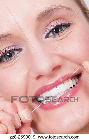 Young woman flossing her clean white teeth. View Large Photo Image Stock Photo - Young woman flossing her clean white teeth.. Fotosearch