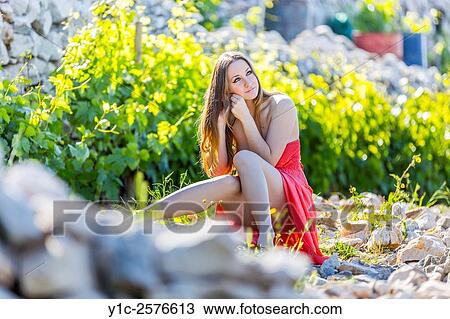Stock Image - Young woman in vineyard in early morning light. Fotosearch