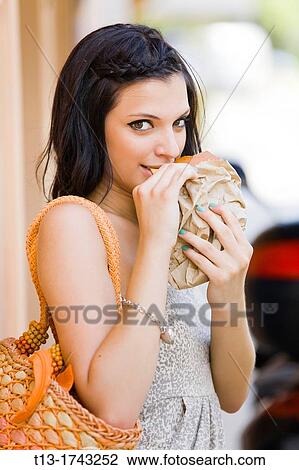 Young woman is eating sandwich View Large Photo Image Stock Image - Young woman is eating sandwich. Fotosearch