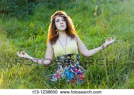 Young woman is meditating in grass View Large Photo Image Stock Image - Young woman is meditating in grass. Fotosearch
