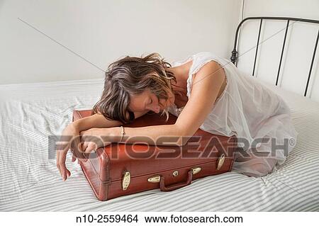 Young woman leaning on her suitcase. View Large Photo Image Picture - Young woman leaning on her suitcase.. Fotosearch