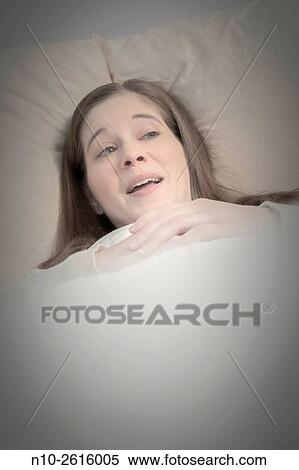 Young woman lying in bed. View Large Photo Image Stock Photography - Young woman lying in bed.. Fotosearch