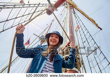 Stock Image - Young woman on the outside of a sailboat, galleon. Masts. Basque Country. Spain. Fotosearch