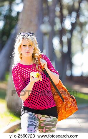 Stock Image - Young woman on vacation eating apple. Fotosearch