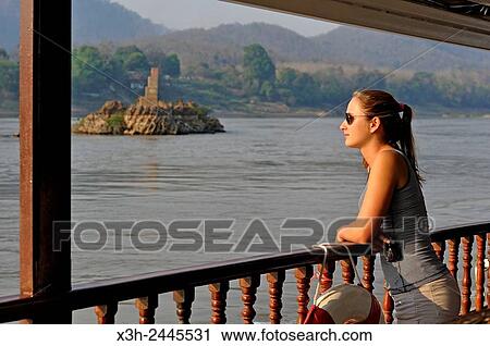 young woman standing at the railing of a cruise boat, owned by?? The Luang Say Lodge & Cruises??, on Mekong River, between Pakbeng and Luang Prabang, Oudomxay Province, Laos, Southeast Asia. View Large Photo Image Stock Image - young woman standing at the railing of a cruise boat, owned by?? The Luang Say Lodge & Cruises??, on Mekong River, between Pakbeng and Luang Prabang, Oudomxay Province, Laos, Southeast Asia.. Fotosearch
