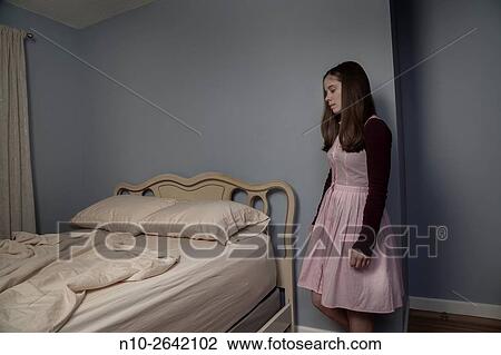 Young woman standing next to an empty bed. View Large Photo Image Stock Image - Young woman standing next to an empty bed.. Fotosearch