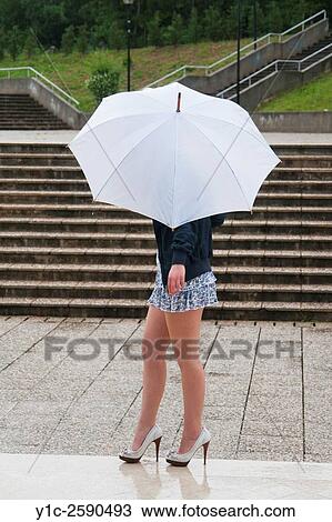 Young woman under White umbrella walking on wet ground View Large Photo Image Stock Image - Young woman under White umbrella walking on wet ground. Fotosearch