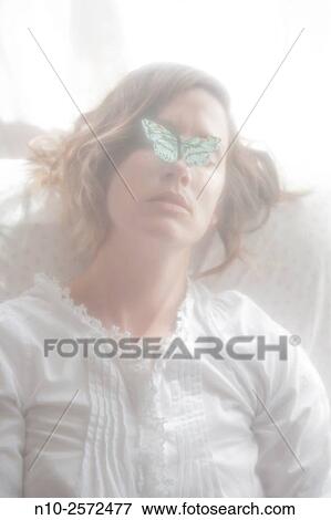 Stock Photo - Young woman with a paper butterfly covering her eyes.. Fotosearch