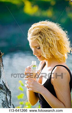 Young woman with bottle of Spring water View Large Photo Image Stock Photograph - Young woman with bottle of Spring water. Fotosearch