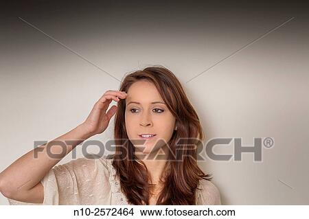 Young woman with her hand on her head. View Large Photo Image Picture - Young woman with her hand on her head.. Fotosearch
