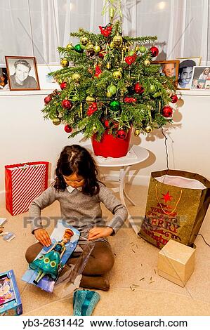A Mixed Race Child Opening Her Christmas Presents On Christmas Day, Brighton, Sussex, UK. View Large Photo Image Stock Image - A Mixed Race Child Opening Her Christmas Presents On Christmas Day, Brighton, Sussex, UK.. Fotosearch