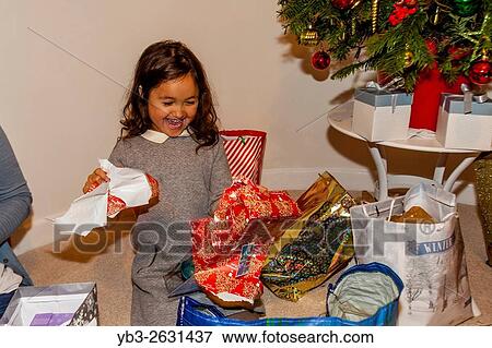 A Mixed Race Child Opening Her Christmas Presents On Christmas Day, Brighton, Sussex, UK. View Large Photo Image Stock Photo - A Mixed Race Child Opening Her Christmas Presents On Christmas Day, Brighton, Sussex, UK.. Fotosearch